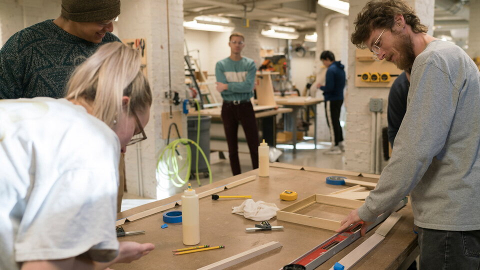 People put together projects at a work table.