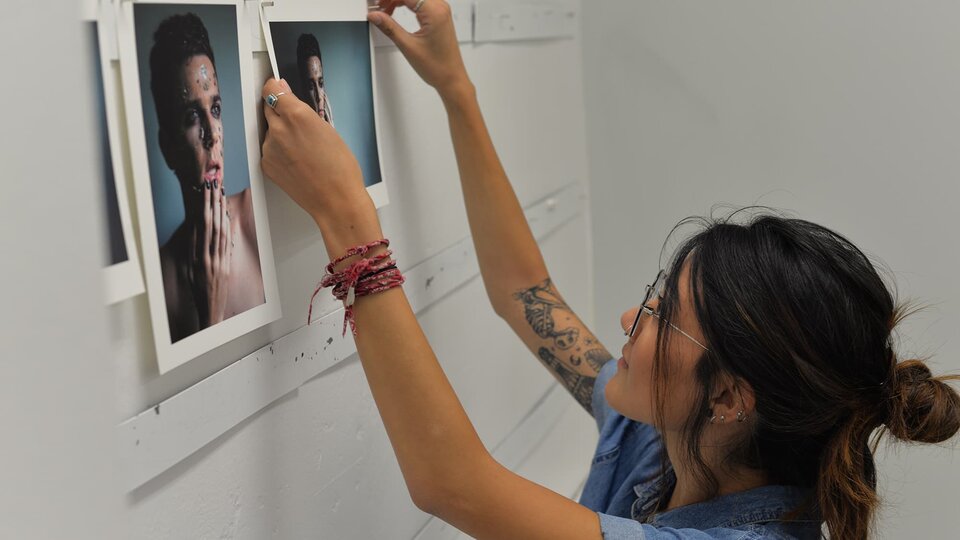 A student posts a photo to a board for group review.